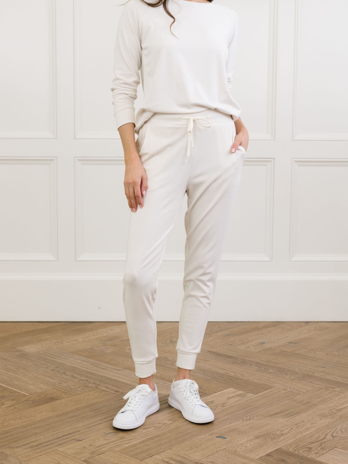 Ivory Bamboo Jogger Set modeled by a woman. The photo was taken in a high contrast setting, showing off the colors and lines of the pajamas. 