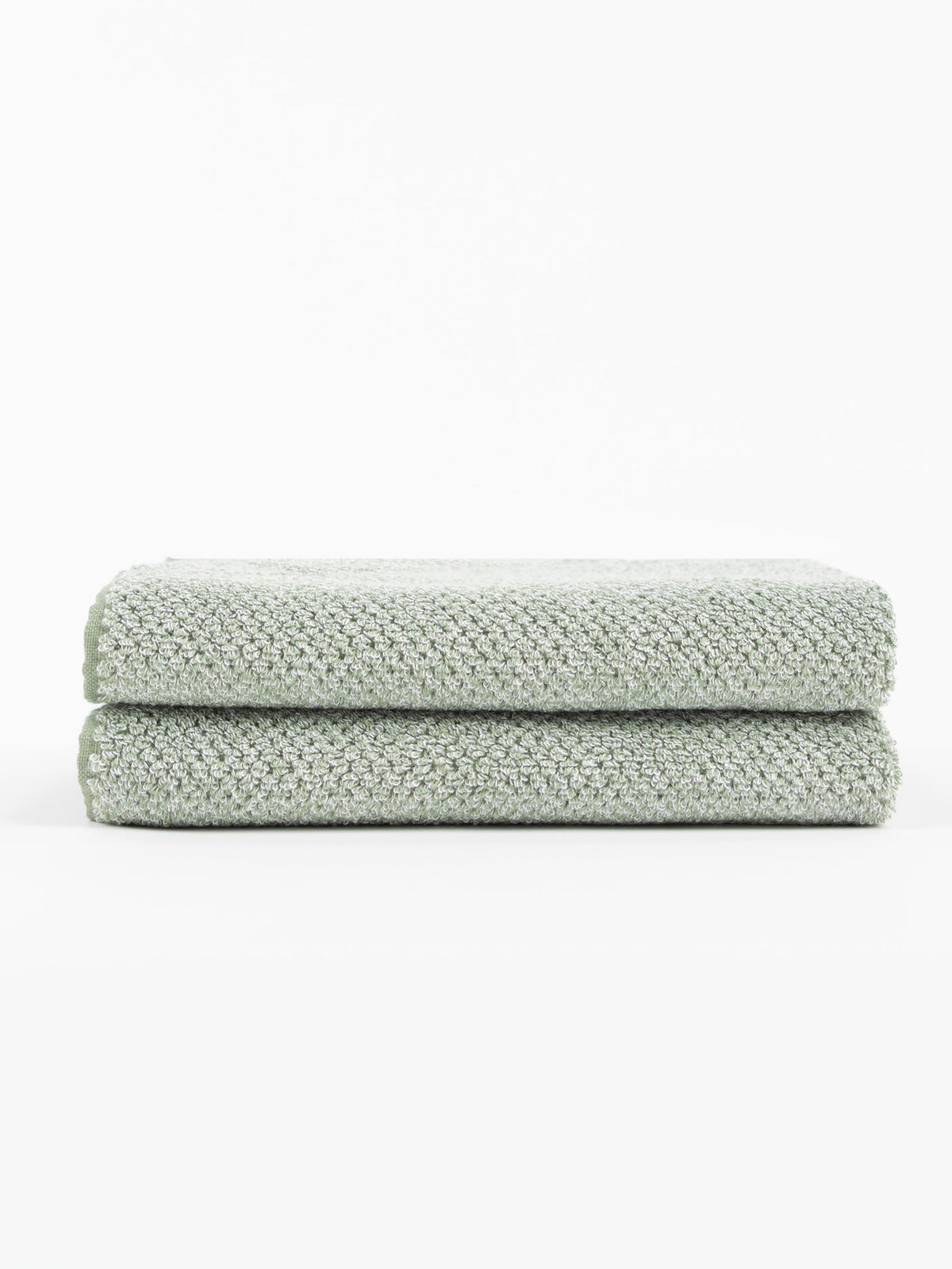 Two neatly folded Nantucket Bath Towel Set towels by Cozy Earth, in light gray with a textured finish, are stacked atop each other against a plain white background.