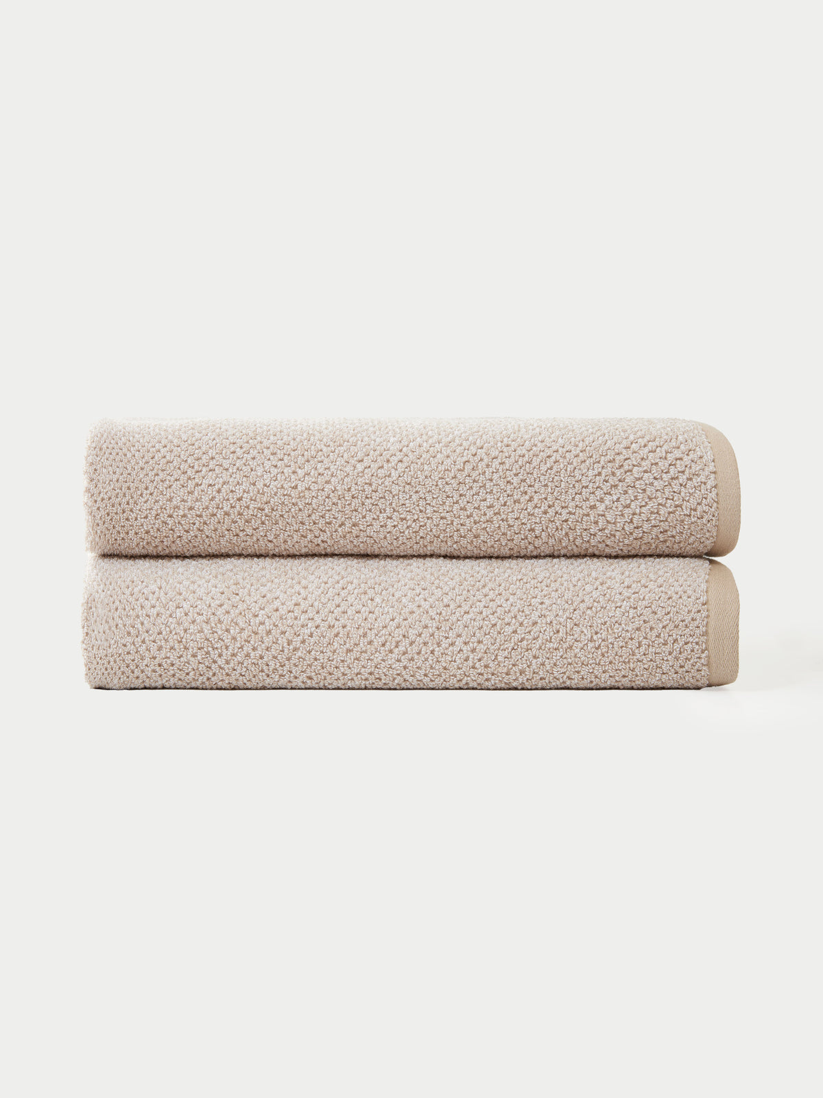 Two Nantucket Bath Towels by Cozy Earth are neatly folded and stacked together against a plain white background.