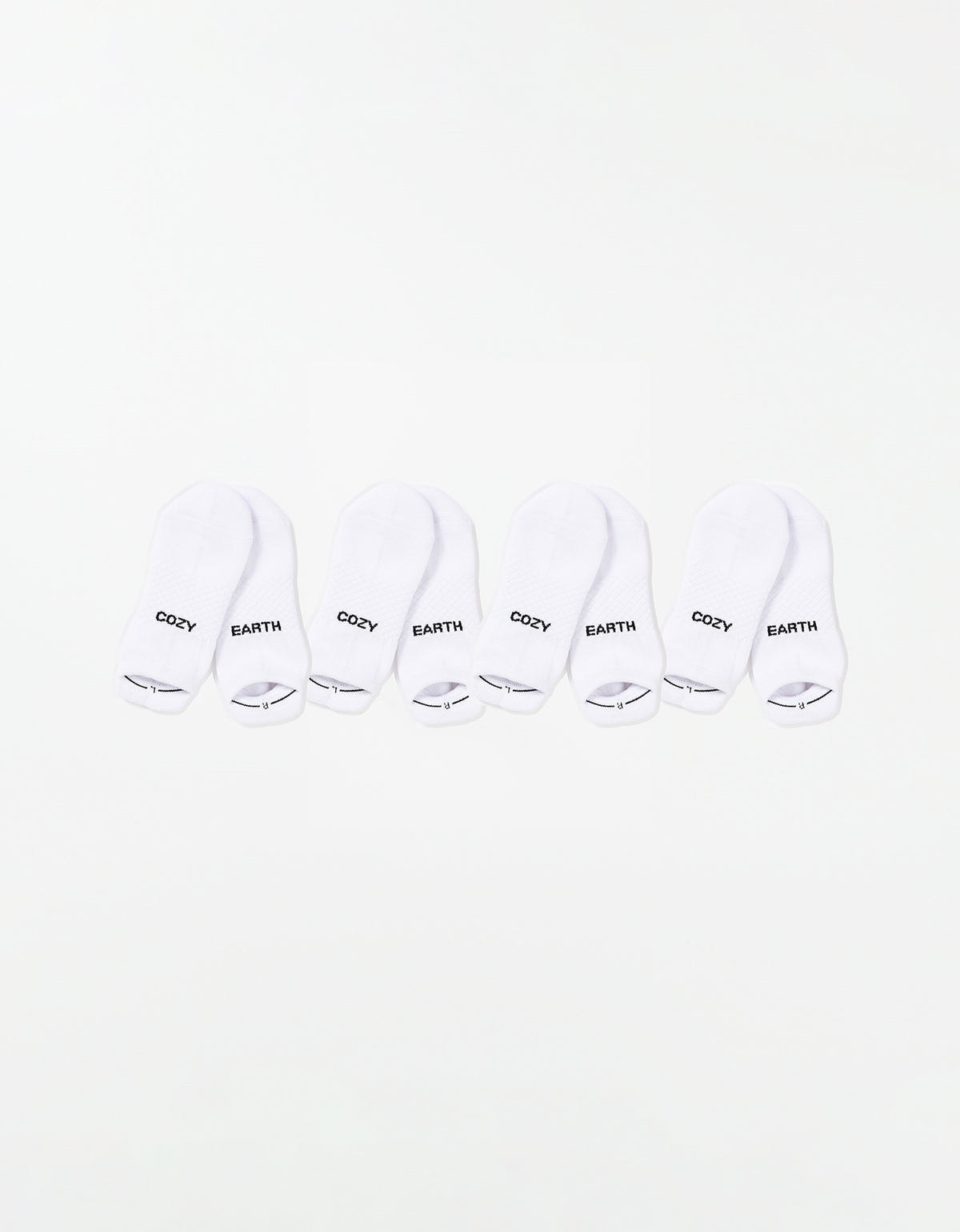 The Essential Ankle Sock 4-Pack by Cozy Earth features four pairs of white ankle socks, each with "COZY" and "EARTH" printed in black on top, arranged in a row on a white background. 