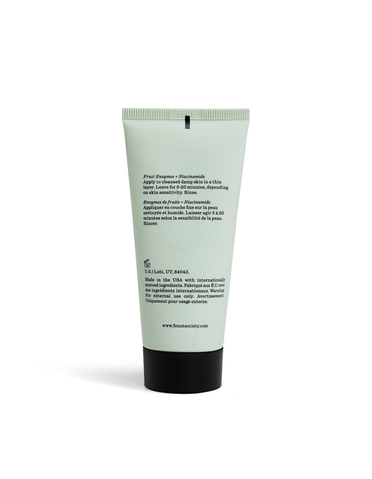 A light green tube of Cozy Earth Enzyme Mask stands upright against a white background, featuring black text on the back with ingredients and usage instructions.