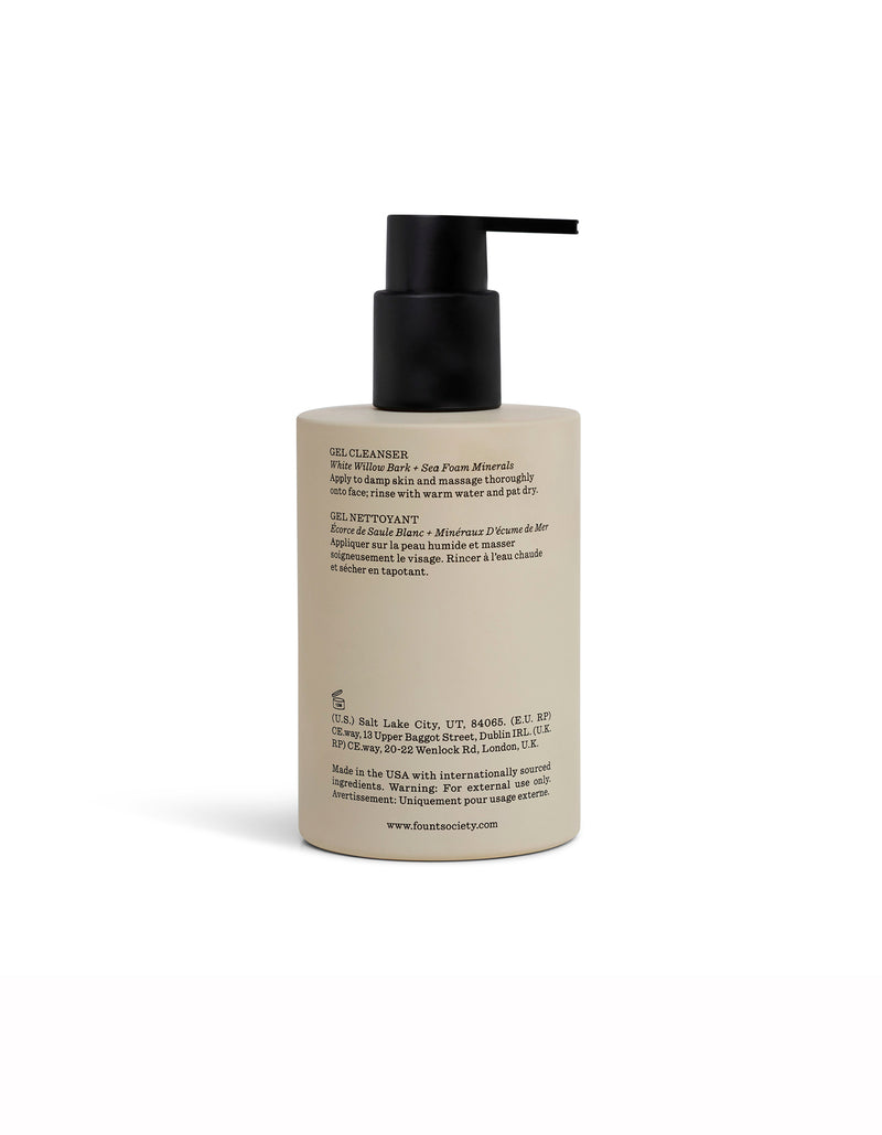 A beige Cozy Earth Gel Cleanser bottle with a black pump dispenser displays English and French details, highlighting sea minerals and soothing botanicals. The product is shown against a white background.