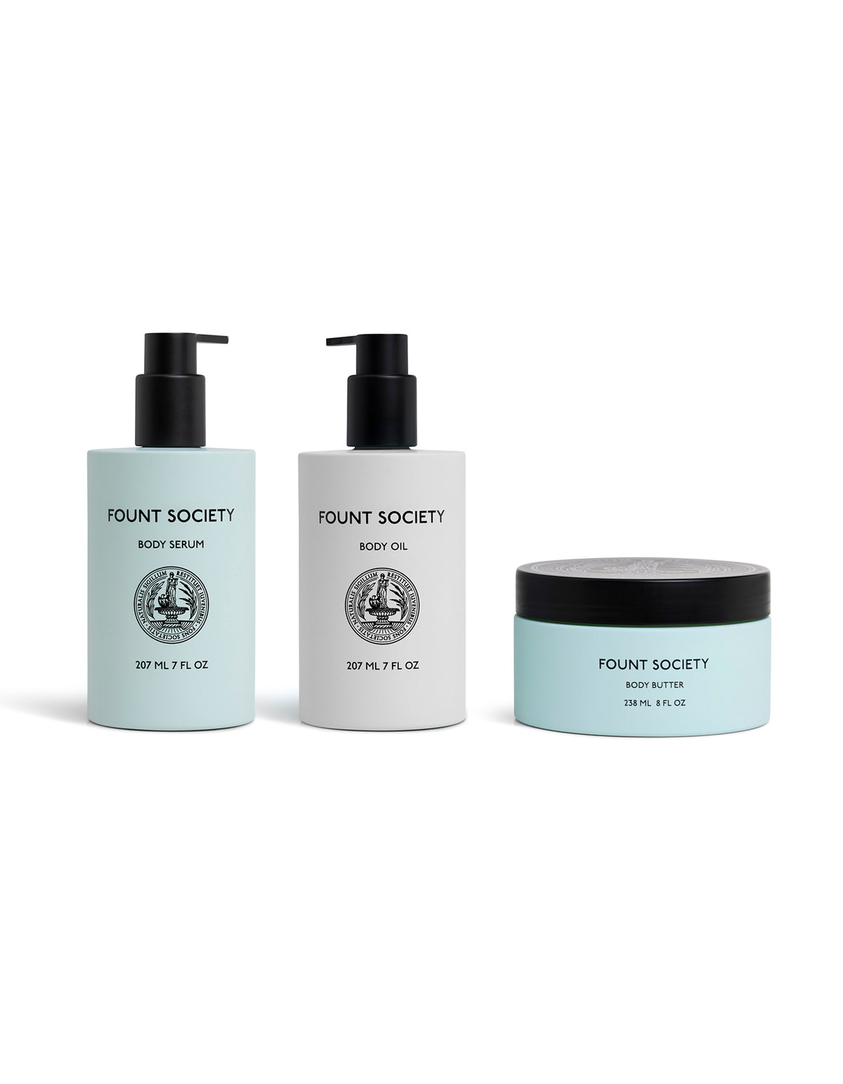 The Cozy Earth Moisture Trio includes a body serum and body oil in sleek white pump bottles, plus a body butter in a light blue jar with black lid—all featuring minimalist black and white labels.