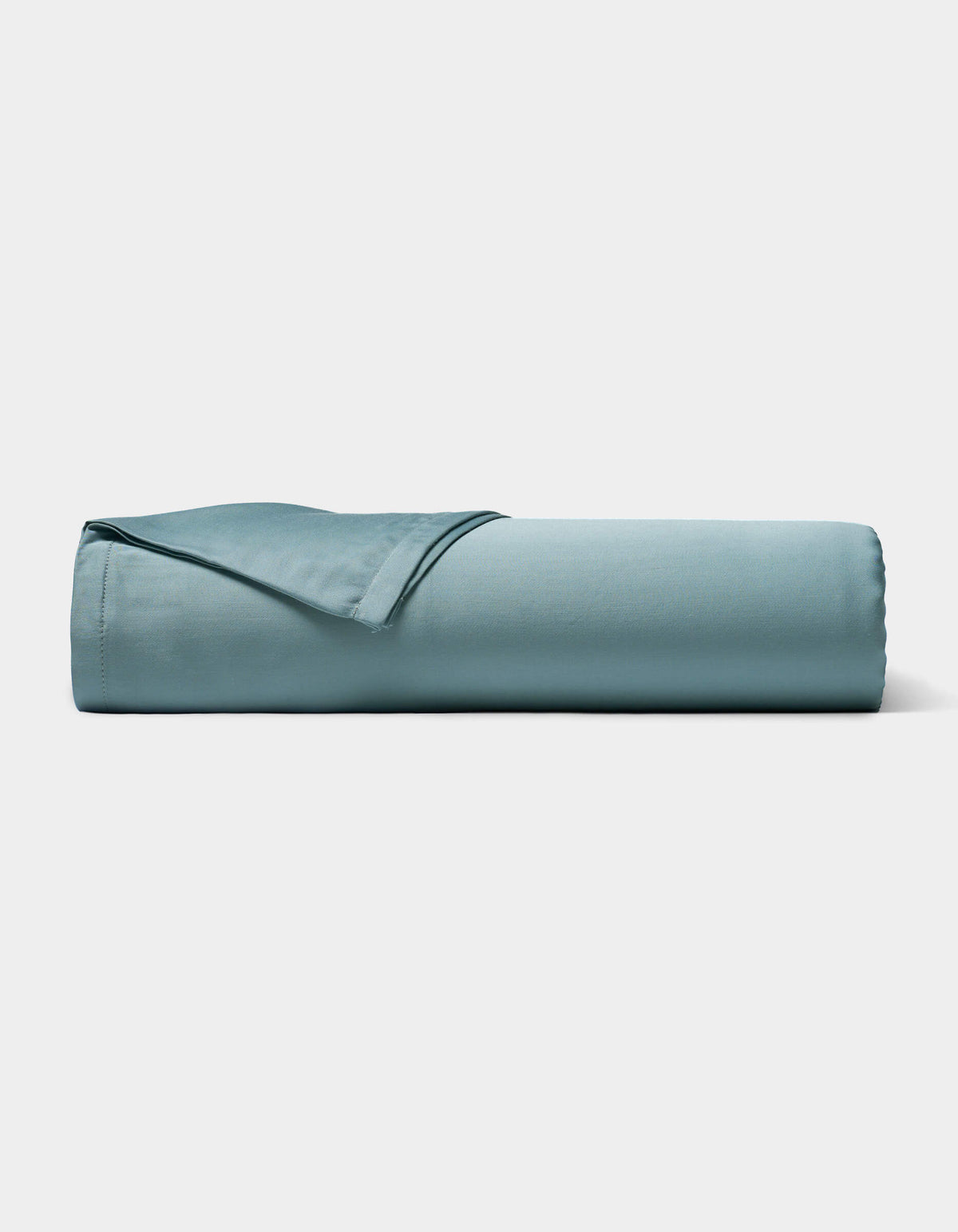 A neatly rolled Bamboo Sheet Set by Cozy Earth in light blue is displayed on a plain white background.