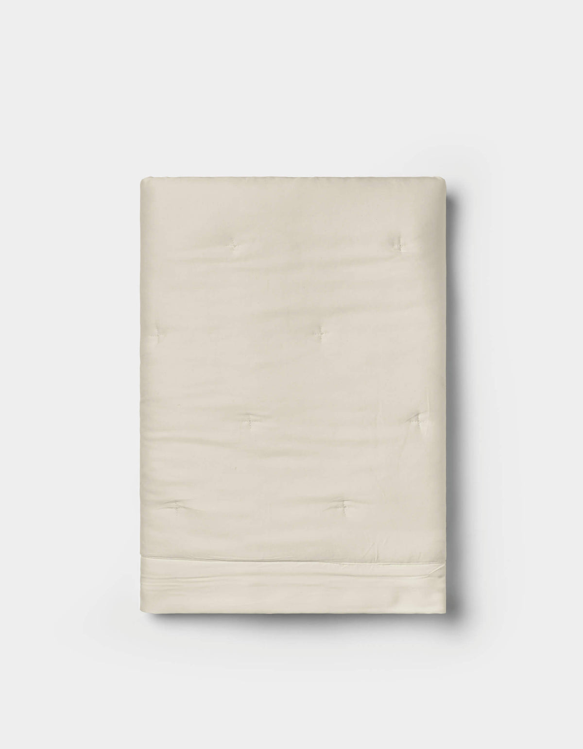 A pair of folded, cream-colored Bamboo Quilted Shams by Cozy Earth, featuring a smooth texture and subtle tufted details, displayed on a white background.