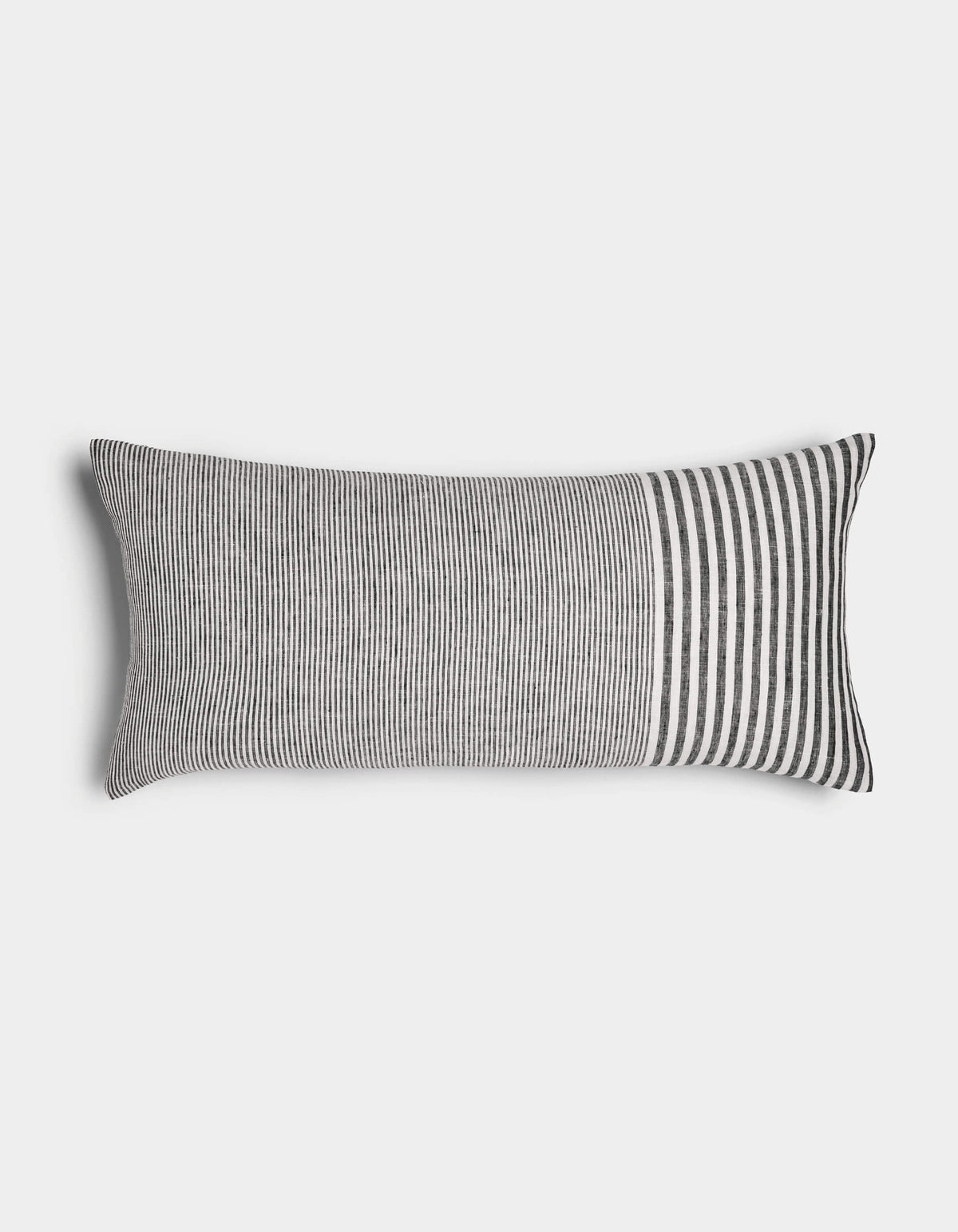 The Cozy Earth Striped Throw Pillow features thin vertical black and white stripes across most of its rectangular surface, with wider stripes at one end, displayed against a plain white background.