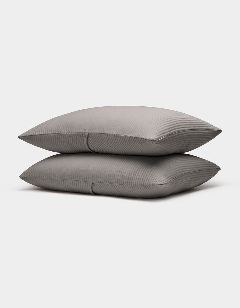 Two neatly stacked Bamboo Coverlet Shams by Cozy Earth in gray with stripes, displayed on a plain white background.