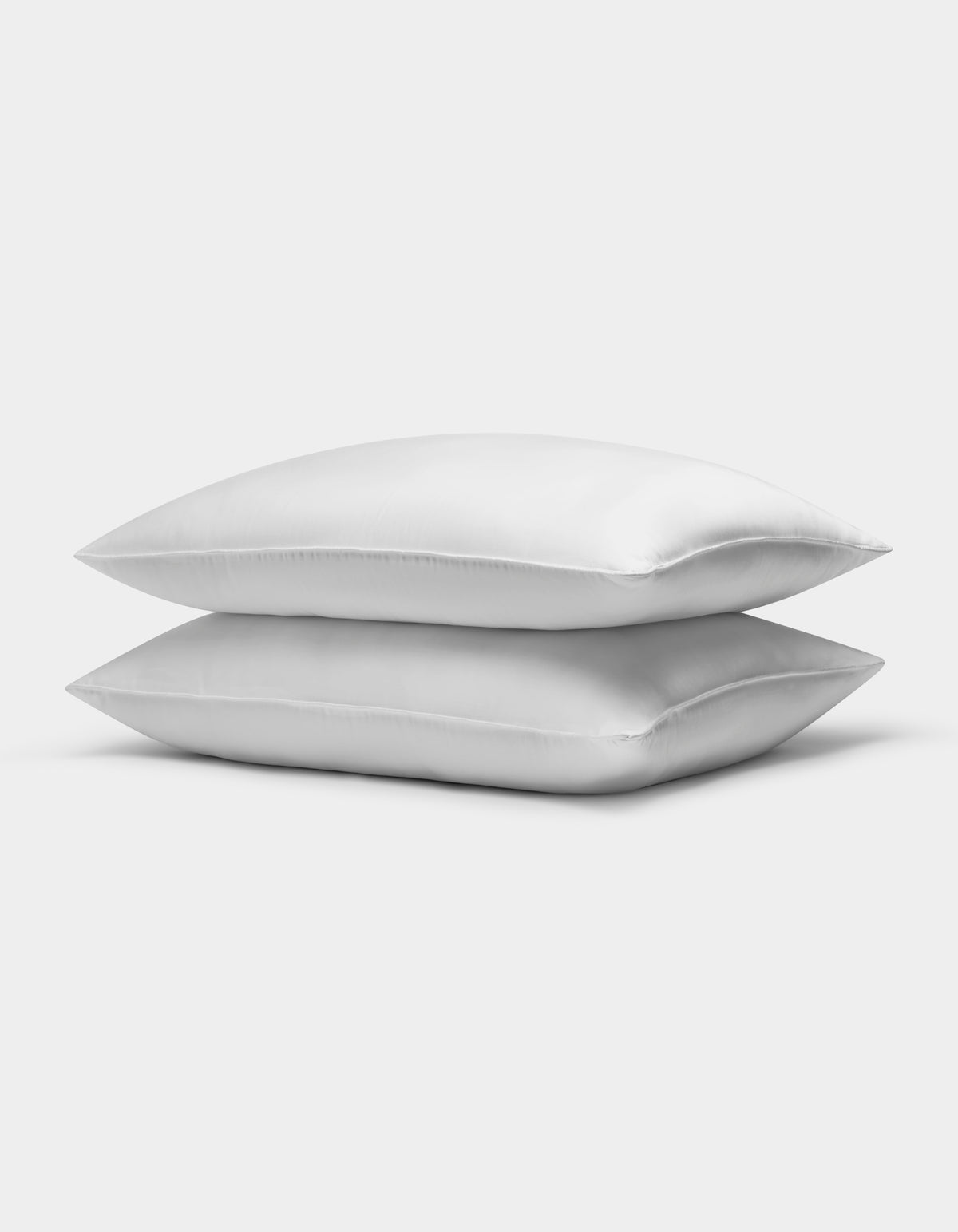 Two clean, white Down Alternative Insert Bundles by Cozy Earth are stacked neatly together against a plain, light gray background.