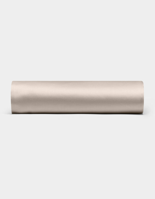 A Cozy Earth Bamboo Fitted Sheet in plain, light beige is shown lying horizontally on a white background, viewed from the side.|Color:Driftwood