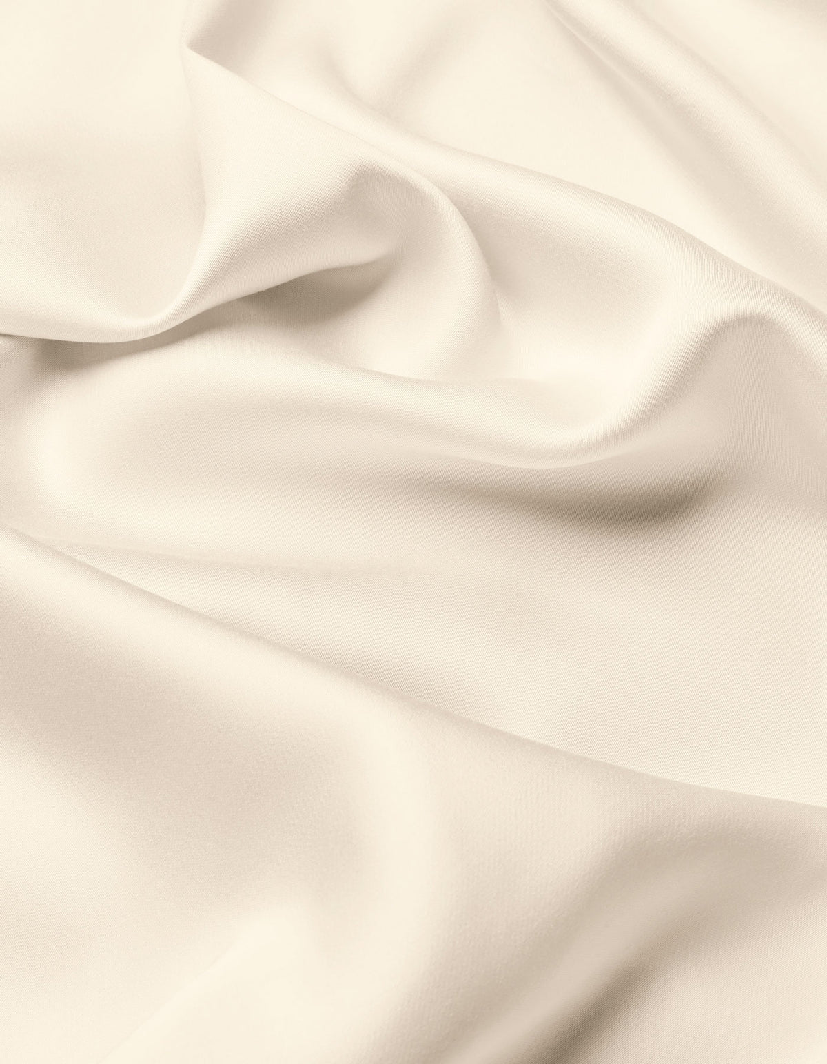 A close-up of the Cozy Earth Bamboo Flat Sheet highlights its smooth, cream-colored fabric with soft folds and gentle shadows, offering a sense of texture and elegance.