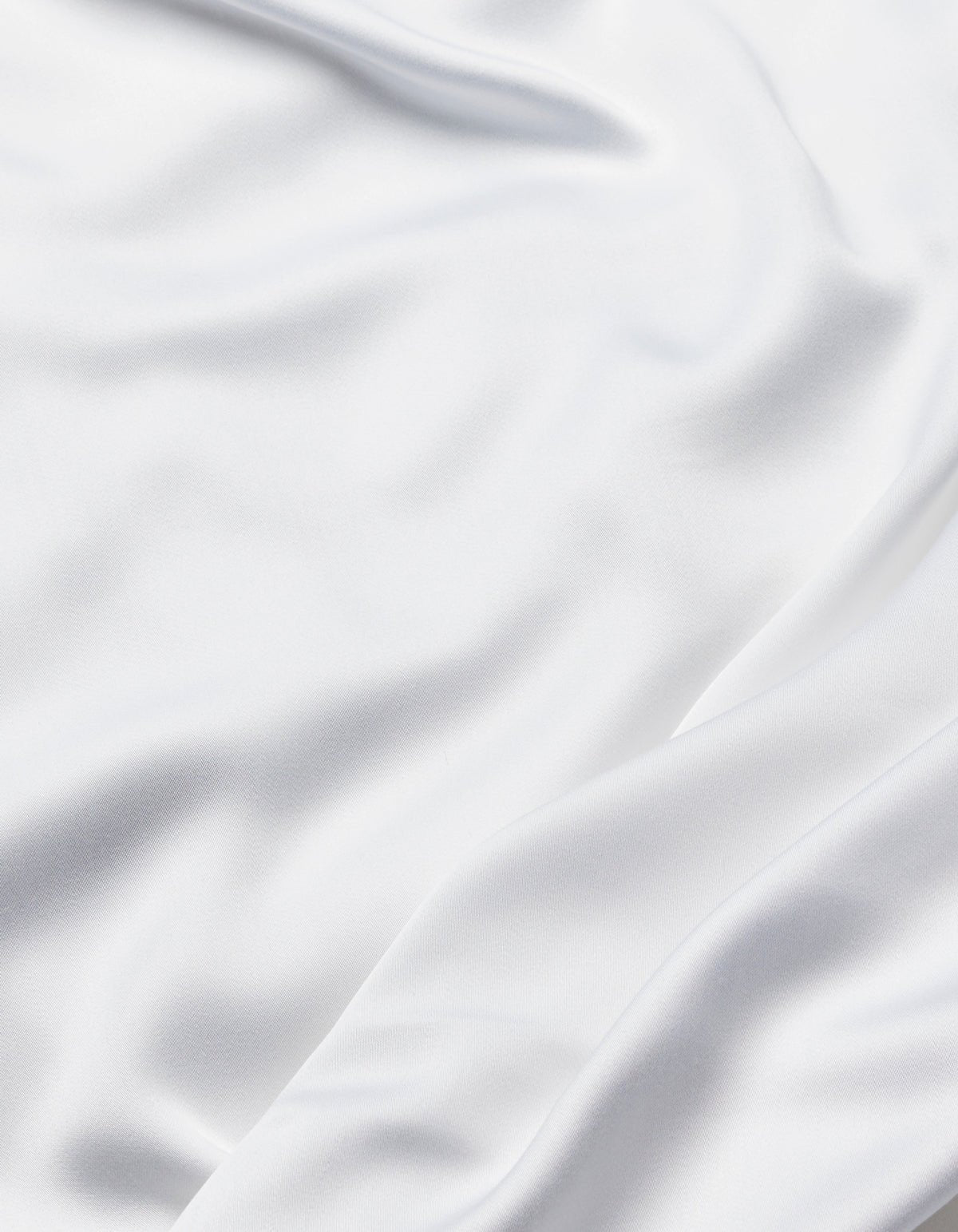 The Cozy Earth Bamboo Flat Sheet features smooth white fabric with soft folds and gentle waves, offering a silky and elegant texture.