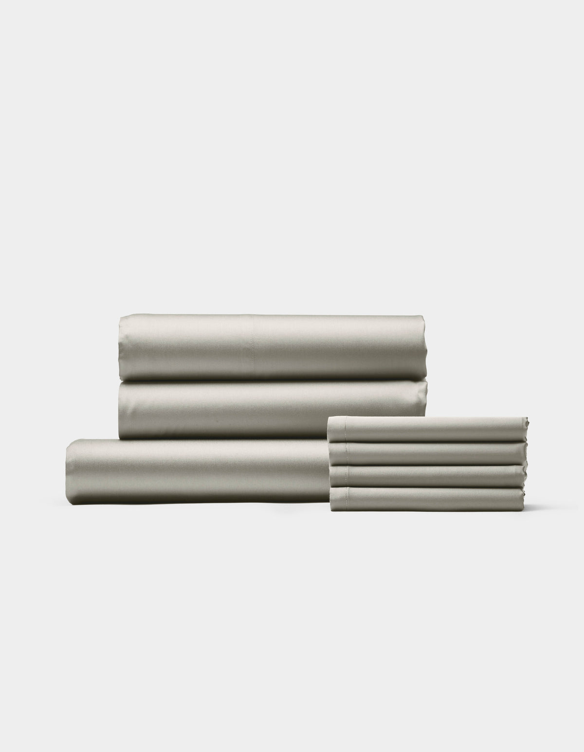 The Cozy Earth Bamboo Bedding Core Bundle, featuring neatly folded light gray sheets and pillowcases, is stacked on a white background with three larger sheets on the left and pillowcases on the right.