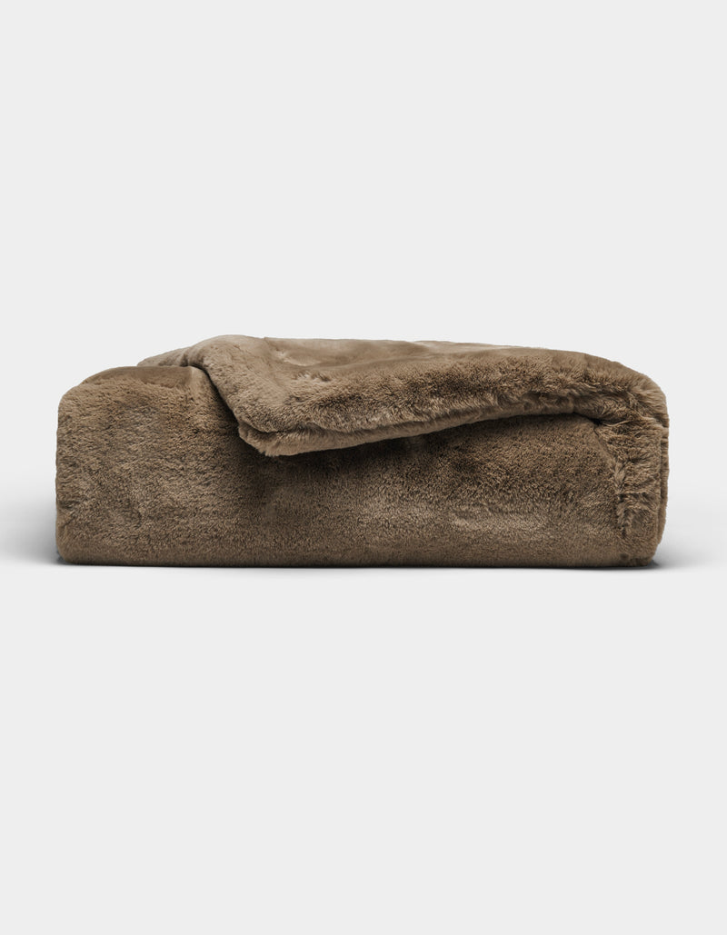 The Cozy Earth Cuddle Blanket, featuring a plush brown fabric and soft, fuzzy texture, is shown folded against a plain white background.