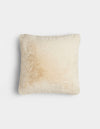 The Cozy Earth Cuddle Pillow is a square, fluffy, cream-colored pillow with a subtle light brown stain on one side, shown against a plain white background.|Color:Creme |Size:20" x 20"