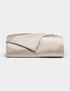 The Bamboo Duvet Cover by Cozy Earth is shown neatly folded in light beige with a smooth, shiny finish against a white background; one corner is flipped open to reveal the inner side.|Color:Driftwood