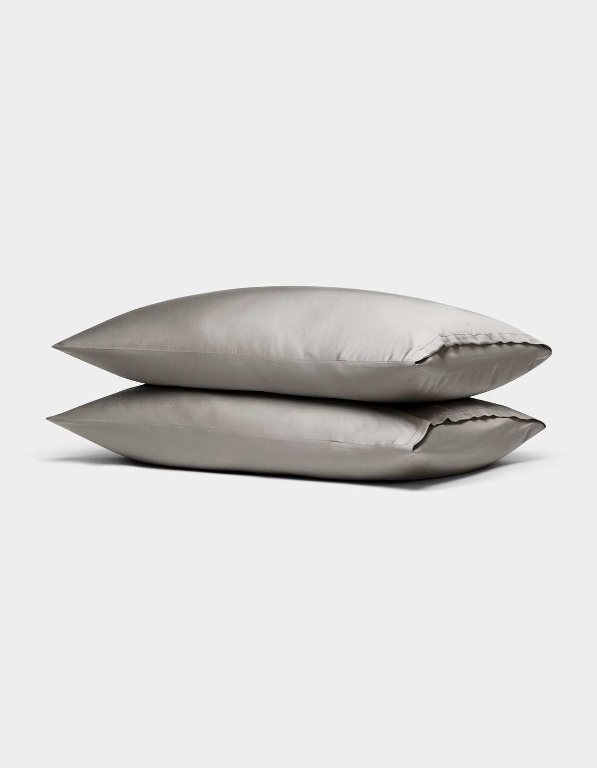 Two Cozy Earth Bamboo Pillowcases in light gray are stacked neatly on top of each other against a plain white background.