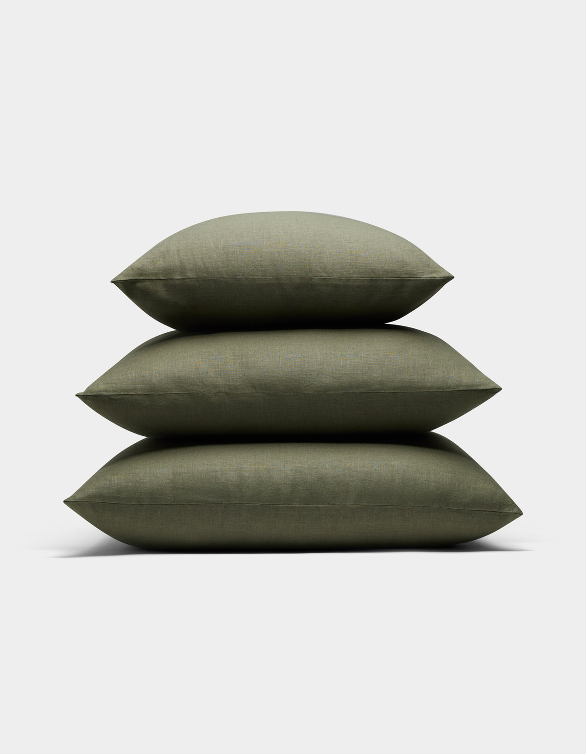 Three Cozy Earth Linen Throw Pillows in olive green are stacked neatly on top of each other against a plain white background.