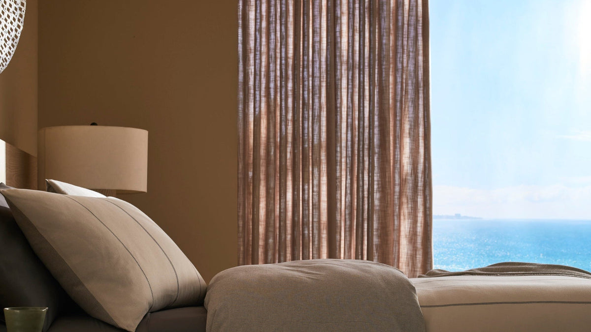 Beige sofa with a lamp and view of the ocean through a window.