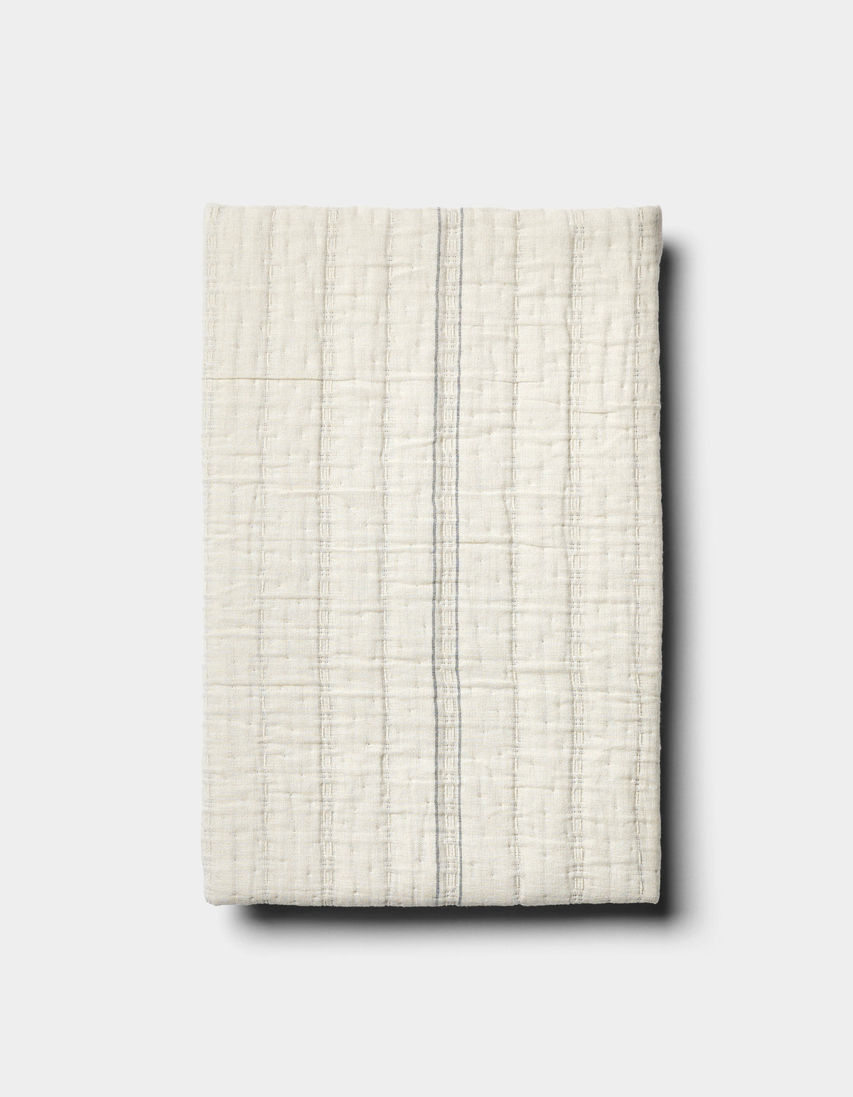 The Baja Matelasse Sham by Cozy Earth features off-white textured fabric with a subtle grid pattern and a single thin grey vertical stripe, displayed on a light grey background.