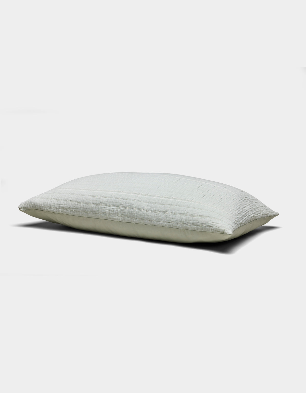 The Baja Matelasse Sham by Cozy Earth is a light-colored, rectangular pillow sham with a soft, textured surface. Displayed against a white background, it looks plush and comfortable.