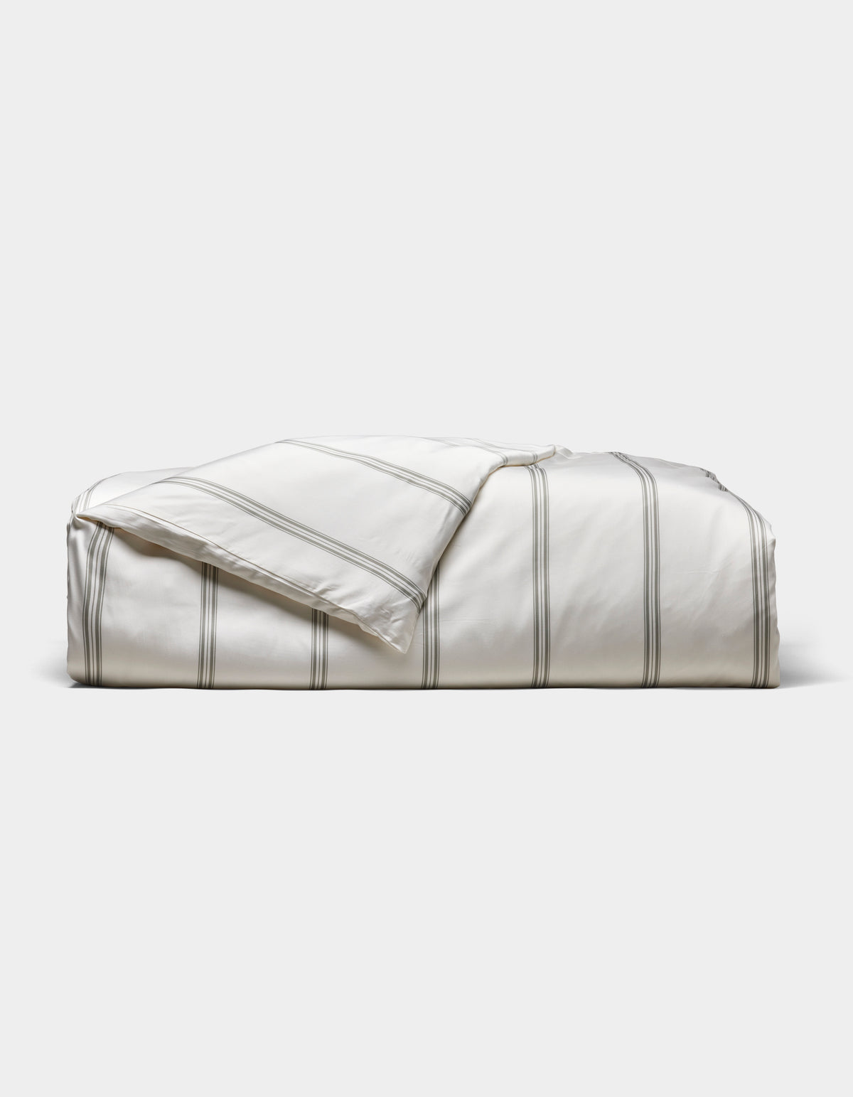 The Cozy Earth Bamboo Duvet Cover, white with thin gray stripes, is neatly folded against a light gray background. A corner is turned down to reveal the underside.