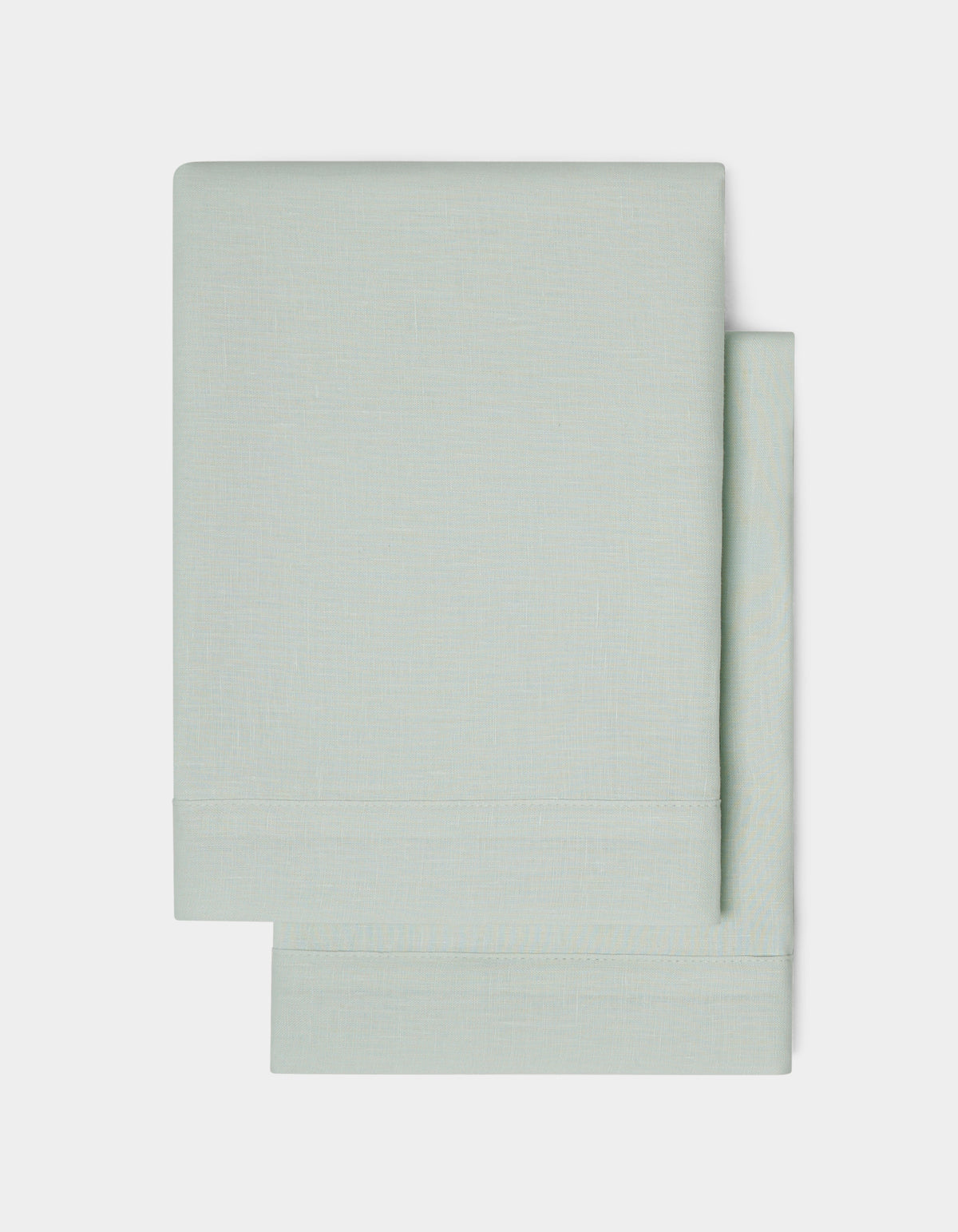 Two neatly folded Linen Shams by Cozy Earth in light gray are stacked on a plain white background, highlighting their simple and clean design.
