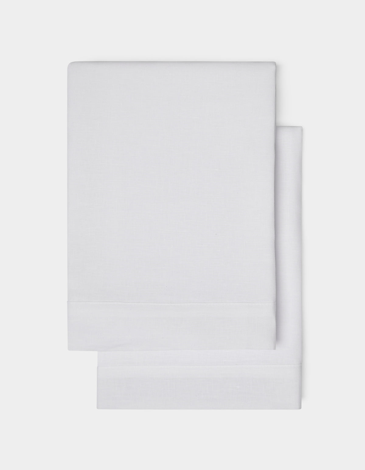 Cozy Earth Linen Shams, neatly folded in plain white with a simple hemmed edge, are shown on a white background.