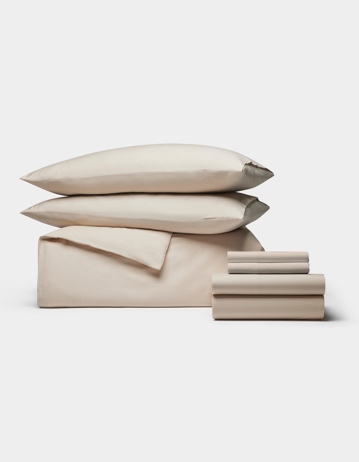 The Cozy Earth Soft-Wash Cotton Bedding Core Bundle features beige sheets, a flat sheet, two pillowcases, and two pillows, all neatly stacked and displayed against a plain white background.|Color:Driftwood