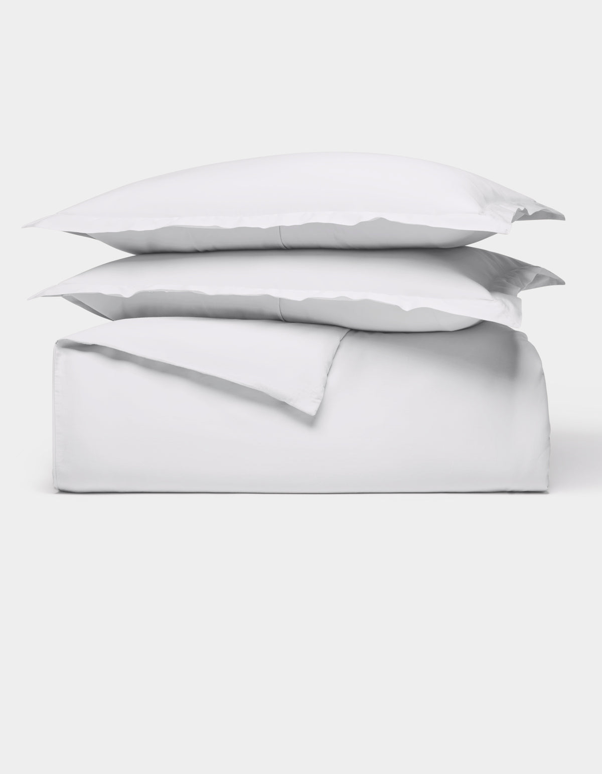 The Cozy Earth Soft-Wash Cotton Duvet Bundle features a neatly folded white sheet set with two stacked pillows, all displayed against a plain white background.|Color:White
