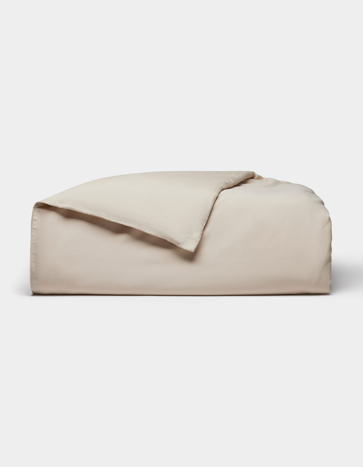 The Cozy Earth Soft-Wash Cotton Duvet Cover, in light beige, is neatly folded with one corner partially flipped over and displayed against a plain white background.|Color:Driftwood