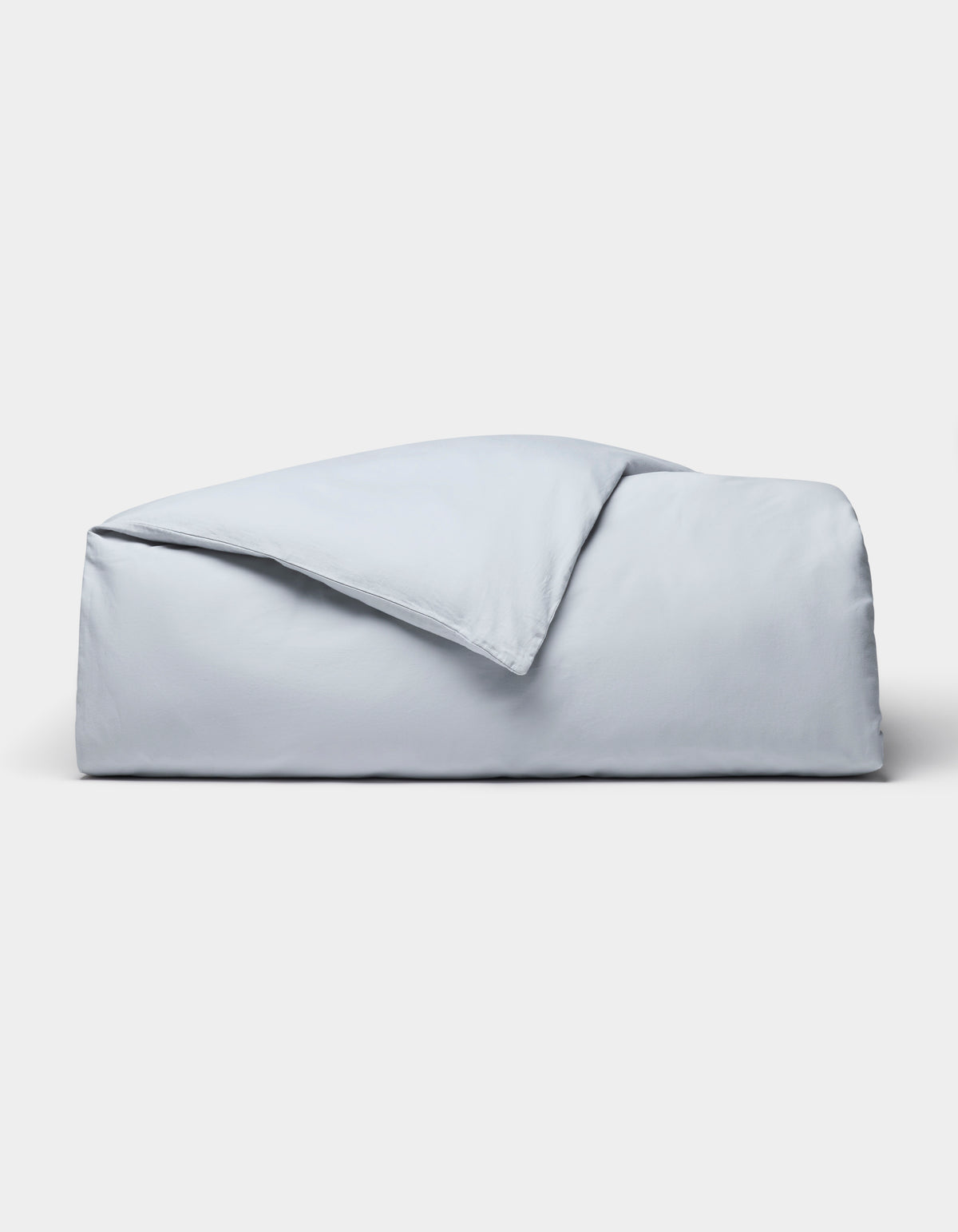 The Cozy Earth Soft-Wash Cotton Duvet Cover set, in light blue, is neatly folded and displayed against a plain white background.