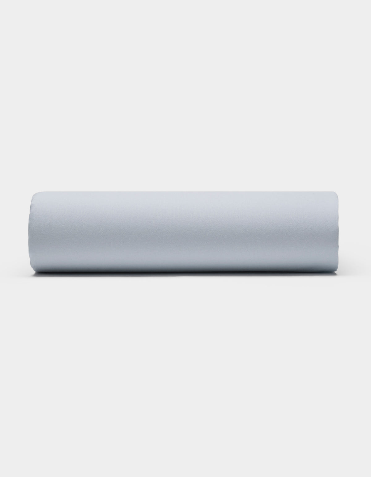 A Soft-Wash Cotton Sheet Set by Cozy Earth is displayed on a plain white background, featuring smooth, light gray fabric arranged neatly to showcase its soft texture.