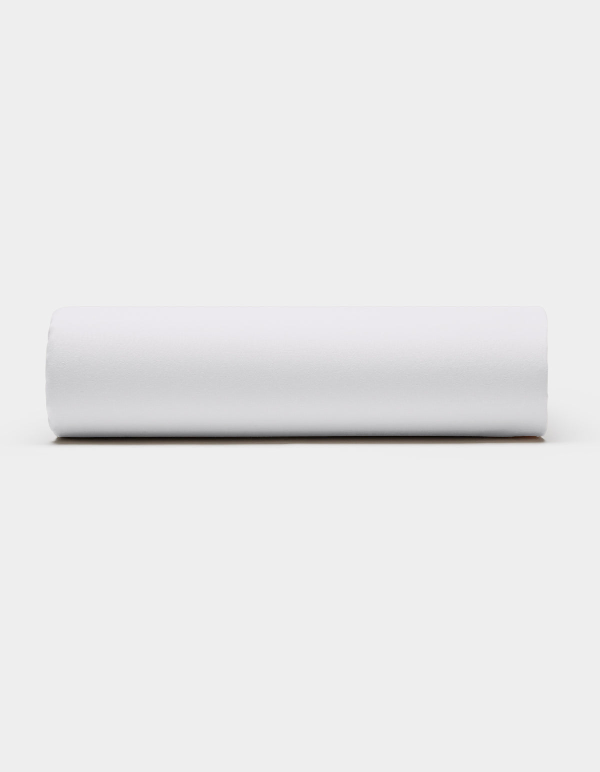 A Soft-Wash Cotton Fitted Sheet by Cozy Earth, in plain white, is displayed horizontally against a light gray background, viewed from the side.|Color:White