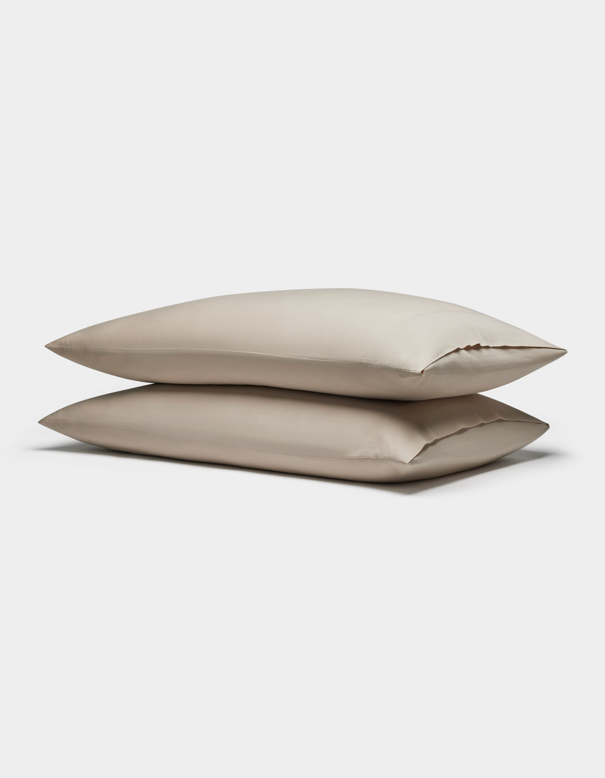 Two Soft-Wash Cotton Pillowcases by Cozy Earth are stacked together against a plain white background.|Color:Driftwood