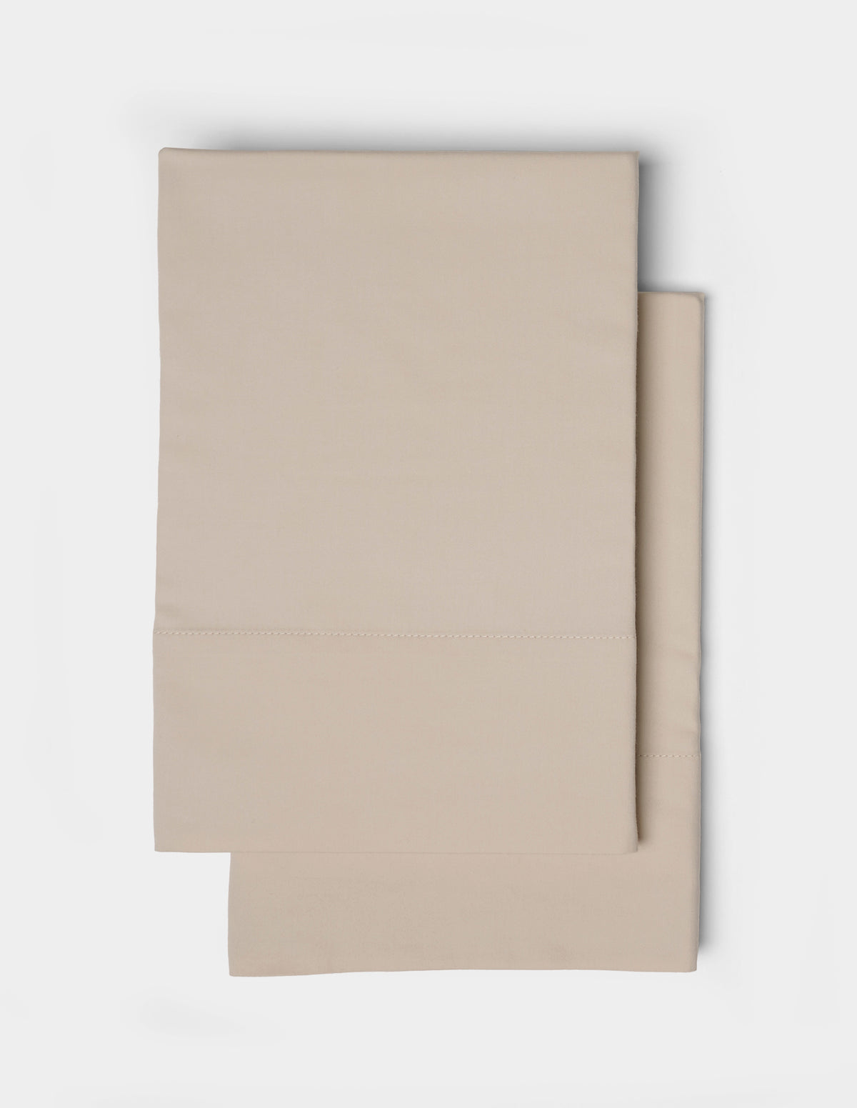 A pair of beige pillowcases from the Cozy Earth Soft-Wash Cotton Sheet Set, featuring a simple stitched border, neatly folded and displayed on a white background.