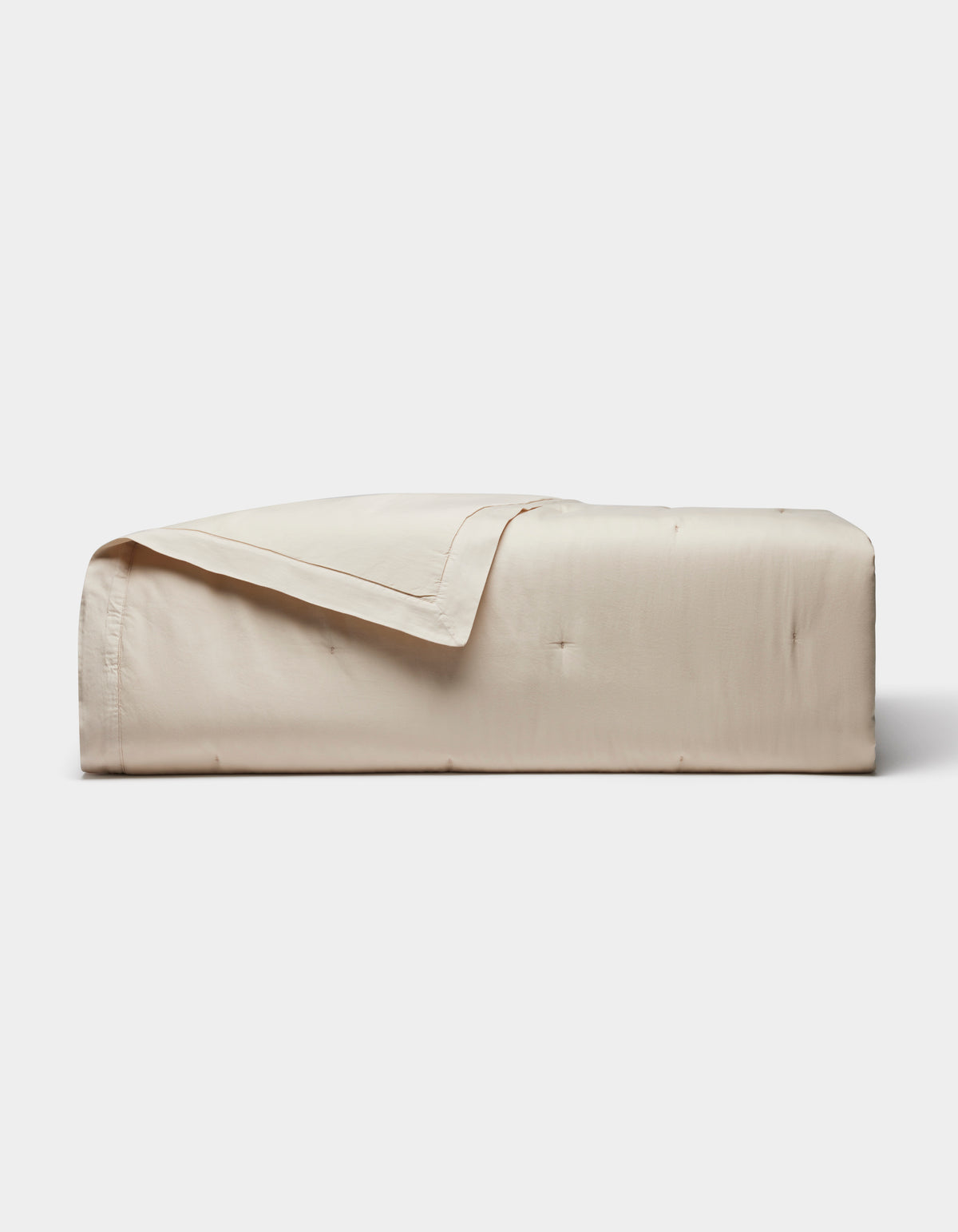 The Cozy Earth Soft-Wash Cotton Quilt, featuring a smooth quilted design in light beige, is neatly folded against a plain white background.|Color:Driftwood
