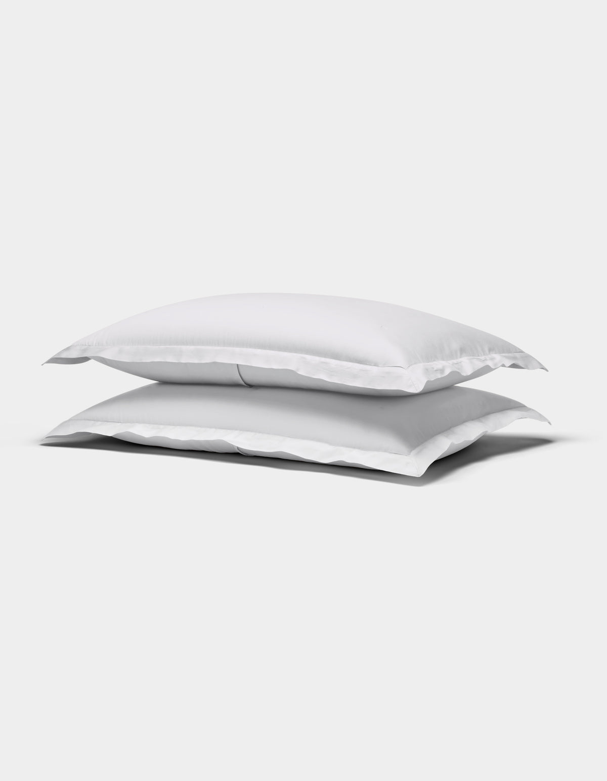 Two Cozy Earth Soft-Wash Cotton Quilted Shams, rectangular and white, are stacked atop each other against a plain white background.