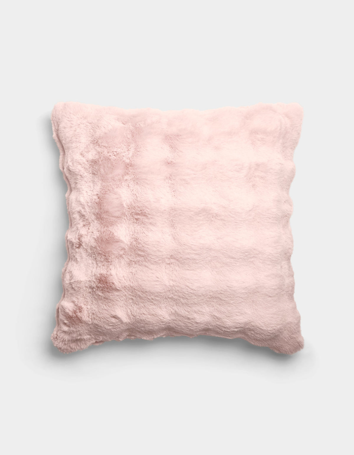 The Bubble Cuddle Pillow by Cozy Earth is a square, pale pink plush pillow with a soft, furry texture and subtle horizontal ridges, shown against a plain light gray background.