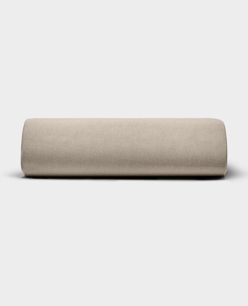 The Bamboo Jersey Fitted Sheet by Cozy Earth, shown in light beige with a smooth fabric texture, is displayed against a plain white background.