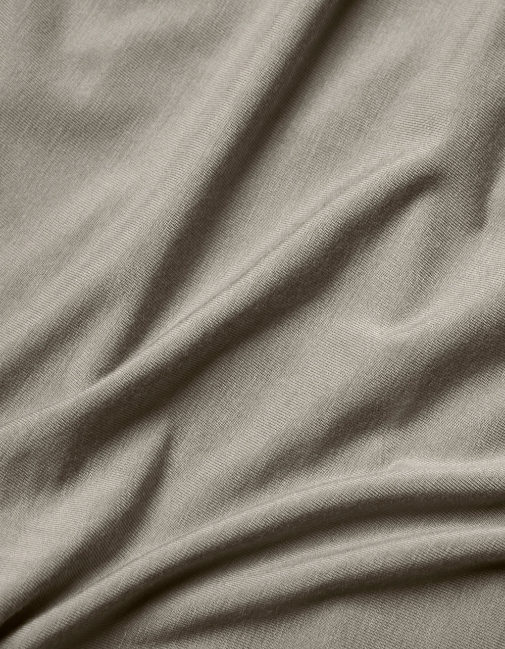 Close-up of the Cozy Earth Bamboo Jersey Flat Sheet in light grey, highlighting its smooth texture, subtle weave pattern, and soft folds.