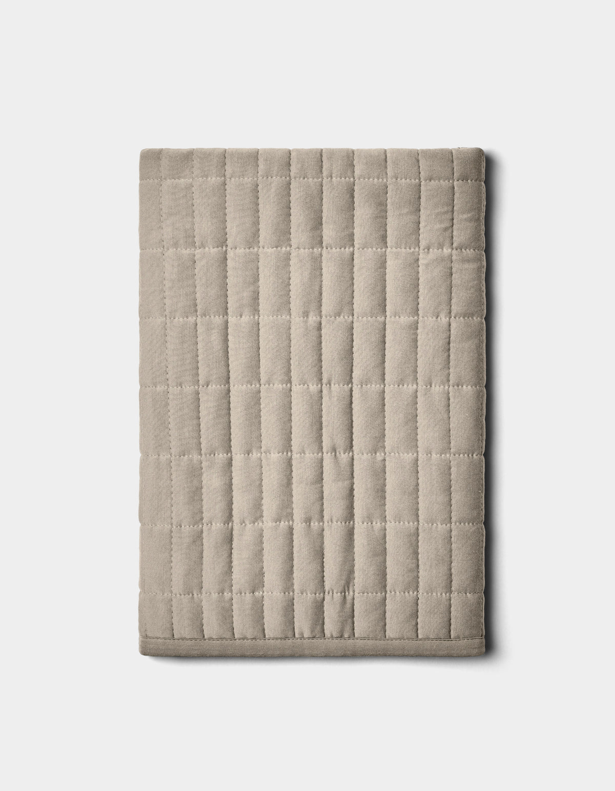 The Bamboo Jersey Quilted Shams by Cozy Earth, shown neatly folded in beige with a grid pattern, are displayed on a plain light background.