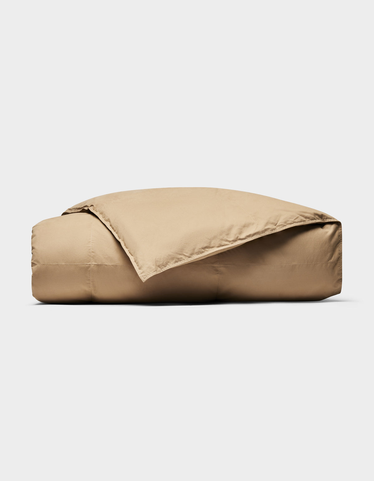 The Cozy Earth Down Alternative Throw, in tan, is neatly folded with one corner draped open against a plain white background.