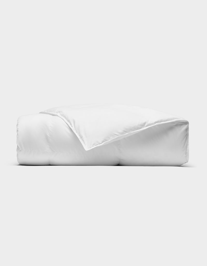 The Cozy Earth Down Alternative Throw is neatly folded against a plain, light background, with one corner turned back to reveal its soft, smooth texture.