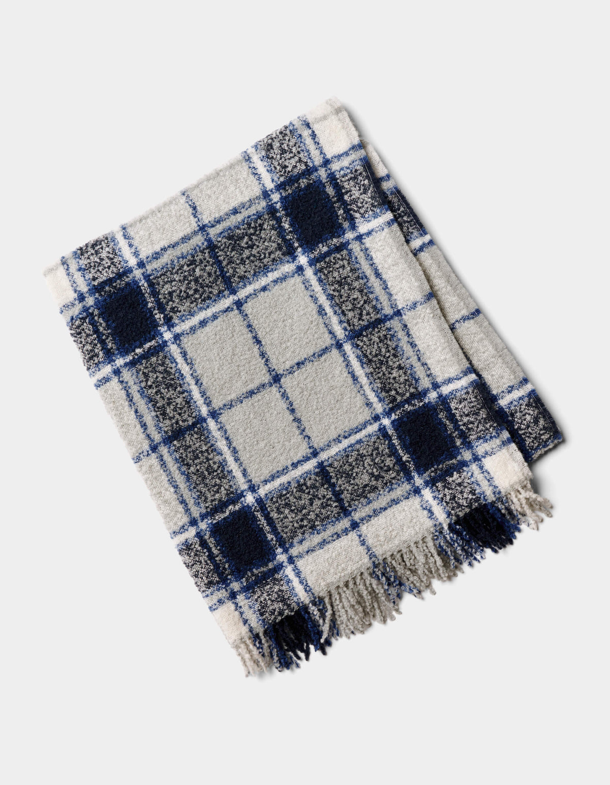 The Cozy Earth Alpaca Boucle Throw, featuring a blue, black, and white plaid design with fringed edges, is shown folded on a light background.