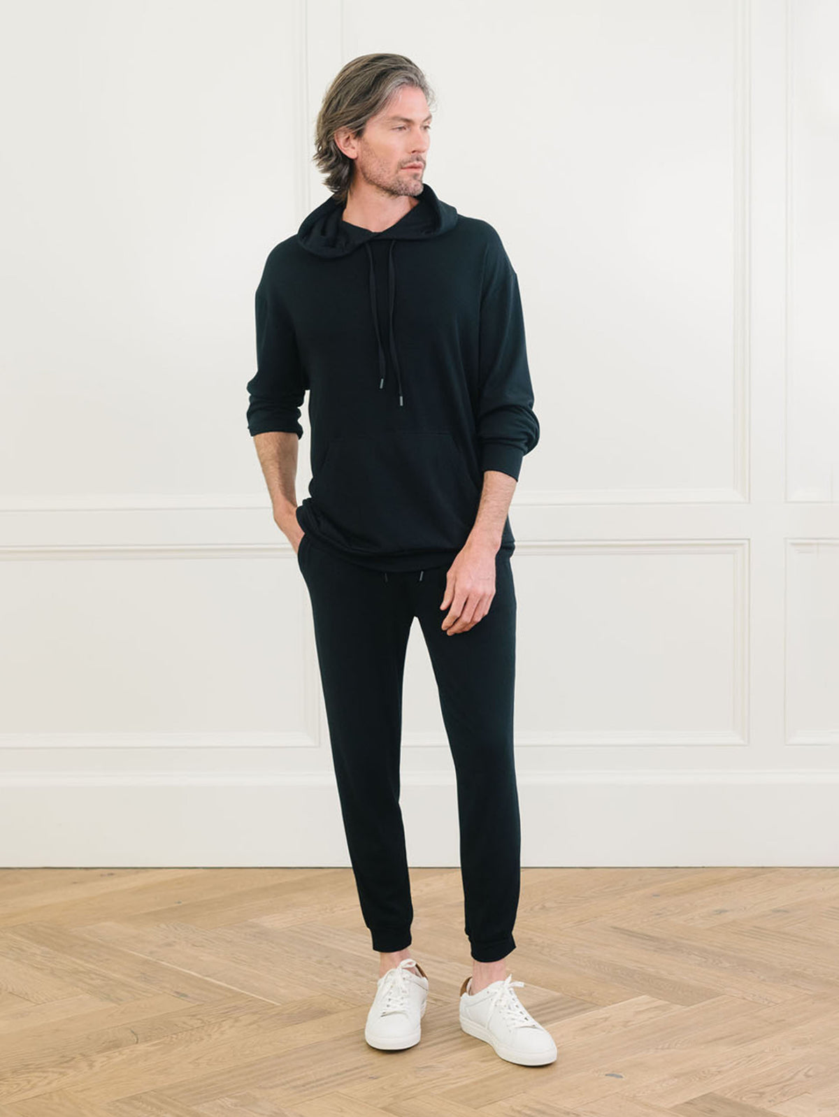 A man wears Men's Brushed Bamboo Hoodie & Jogger Set in Black. 