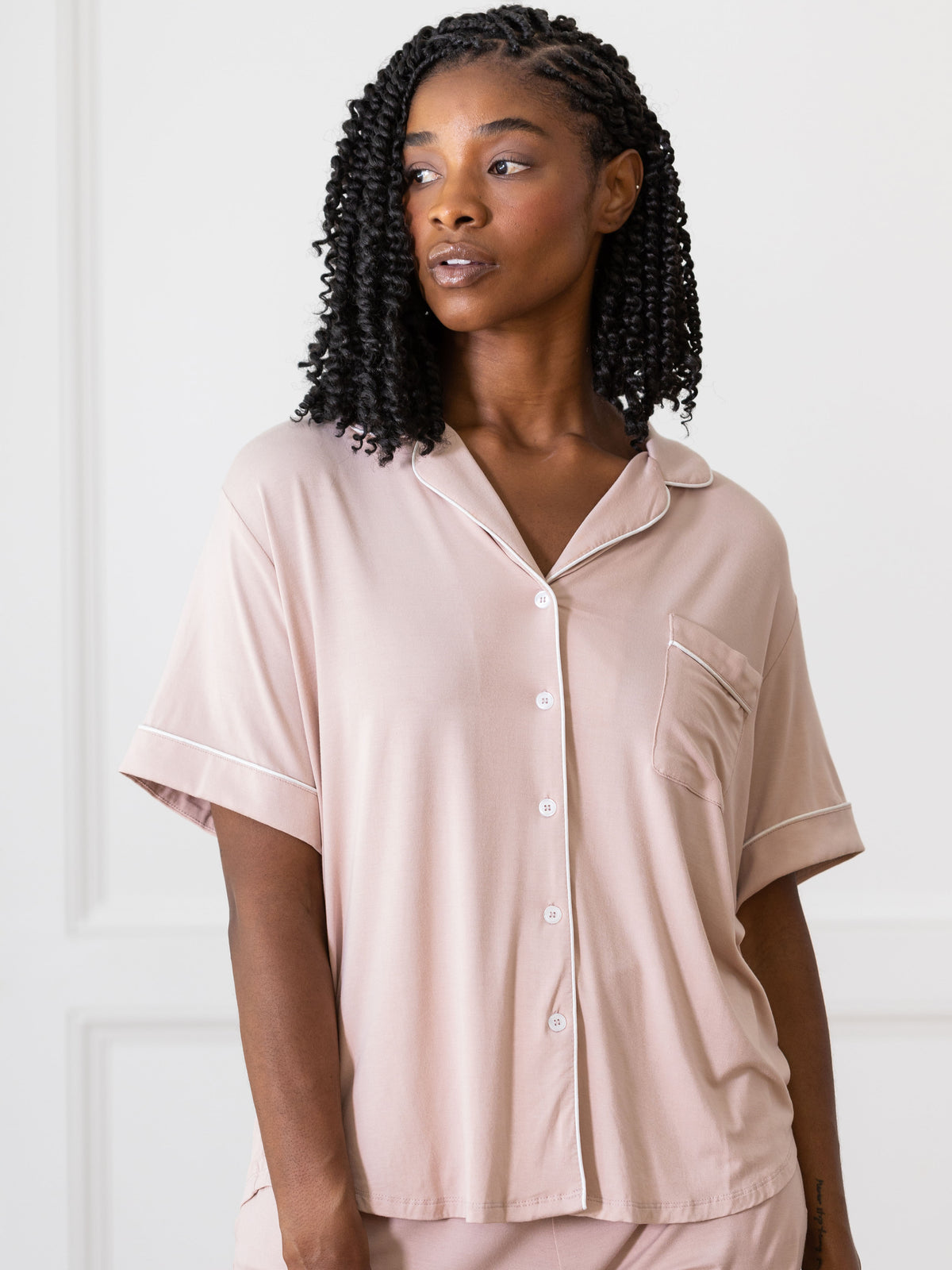 Blush Short Sleeve Pajama Set modeled by a women. The photo was taken in a light setting; showing off the pajamas. 