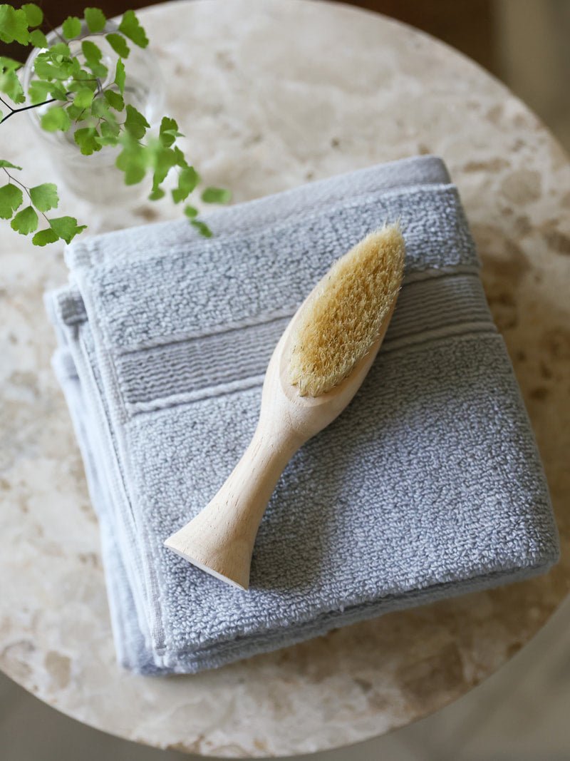 Harbor mist washcloths folded on small table with brush 