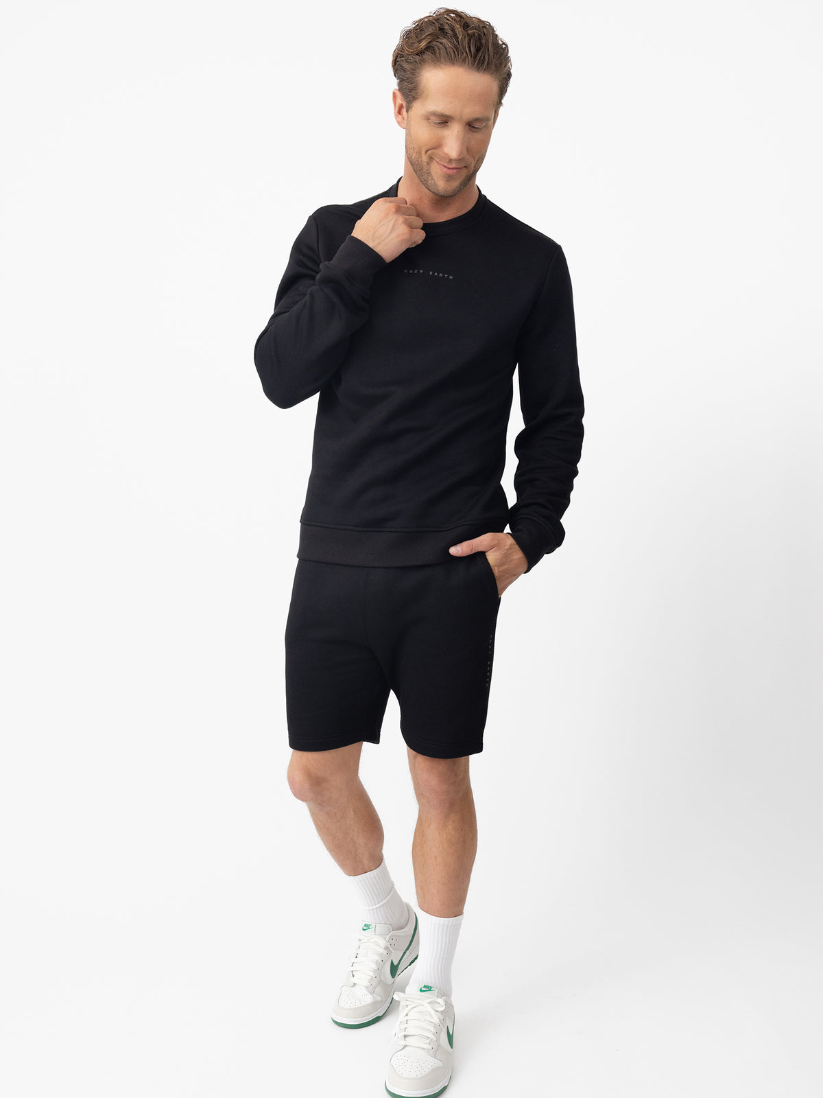 Man wearing black cityscape pullover and shorts with white background 