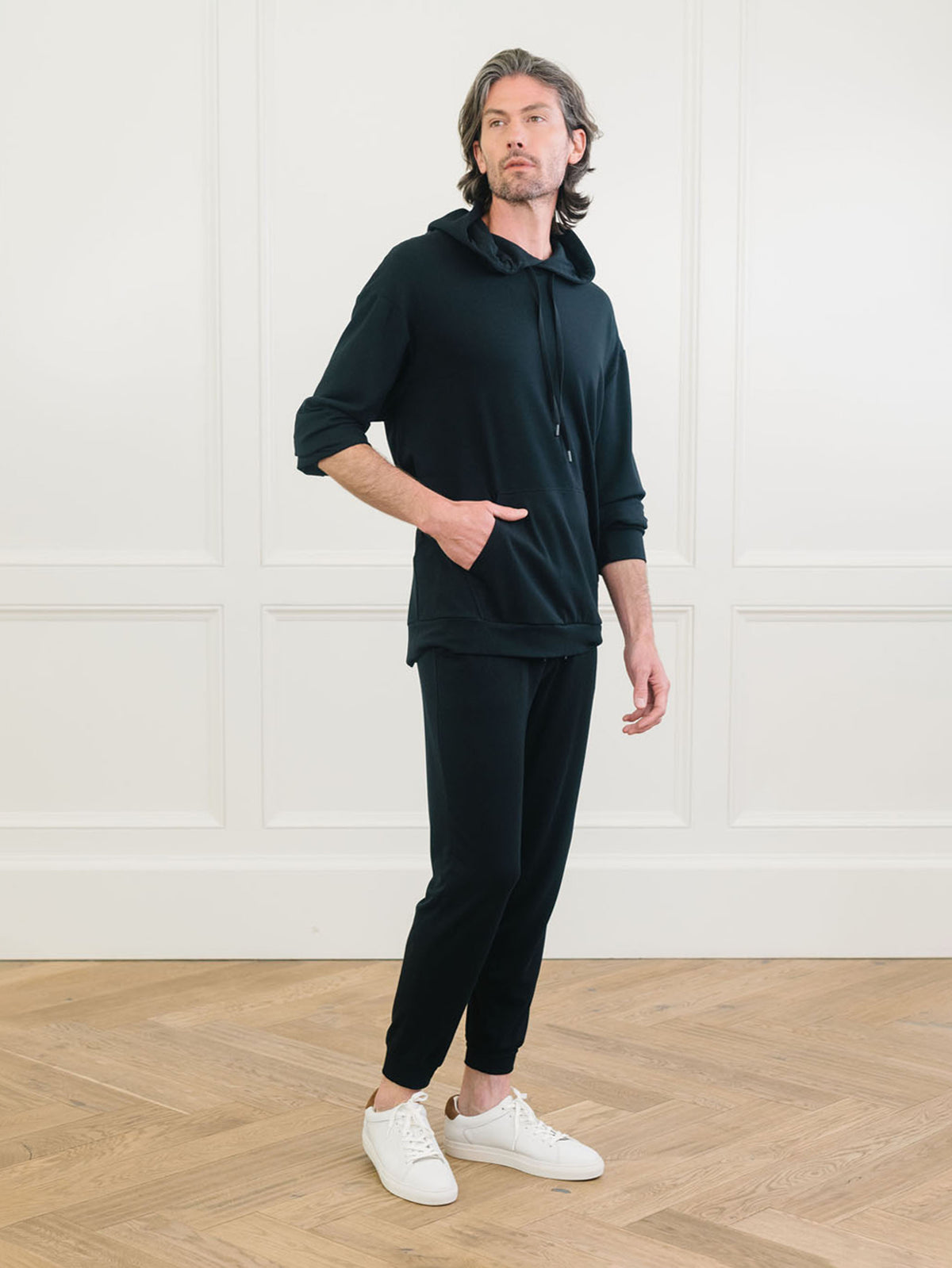 A man wears Men's Brushed Bamboo Hoodie & Jogger Set in Black. 