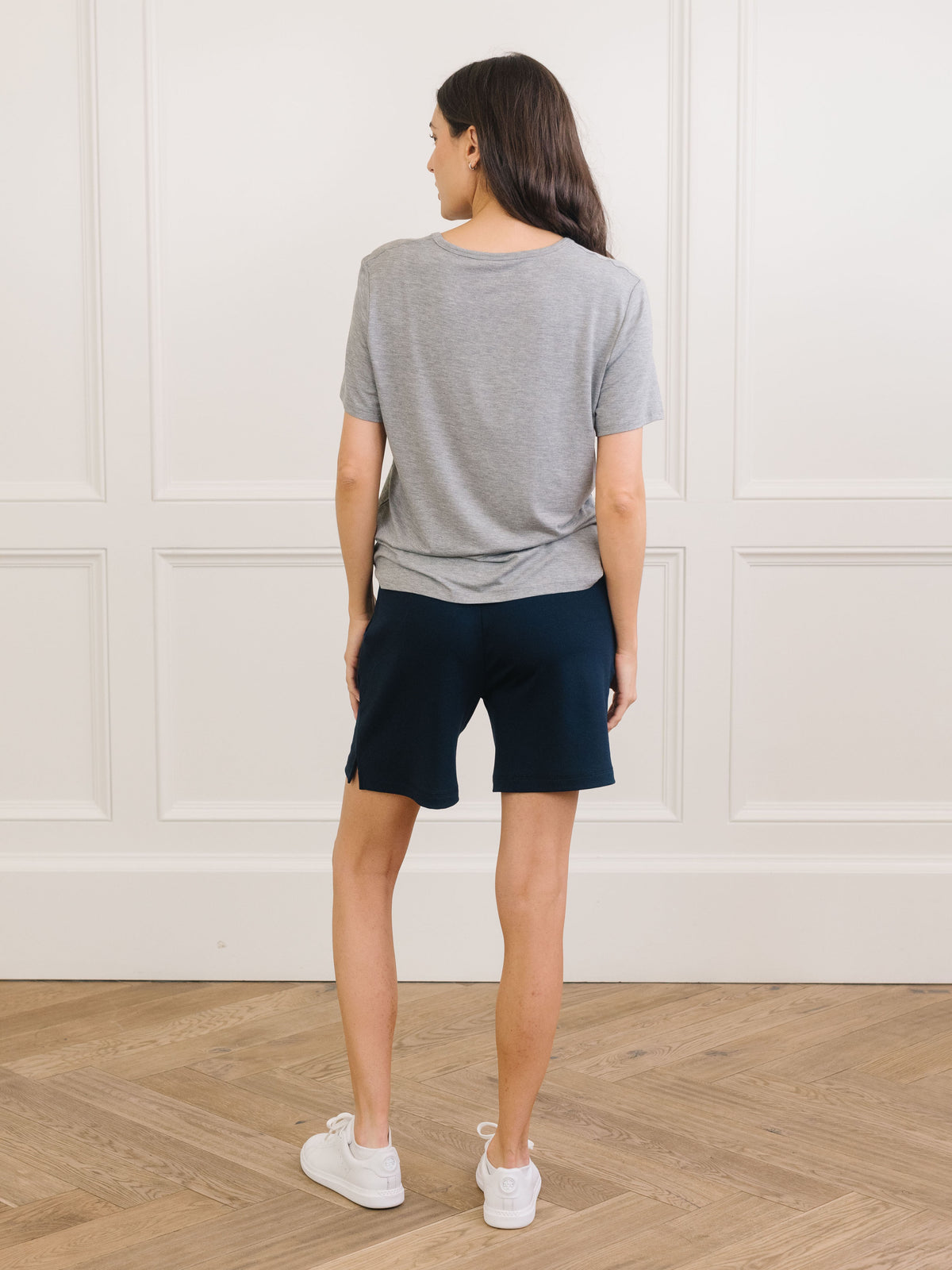 Woman wearing Cozy Earth Bamboo Lounge Tee in grey faces backward 
